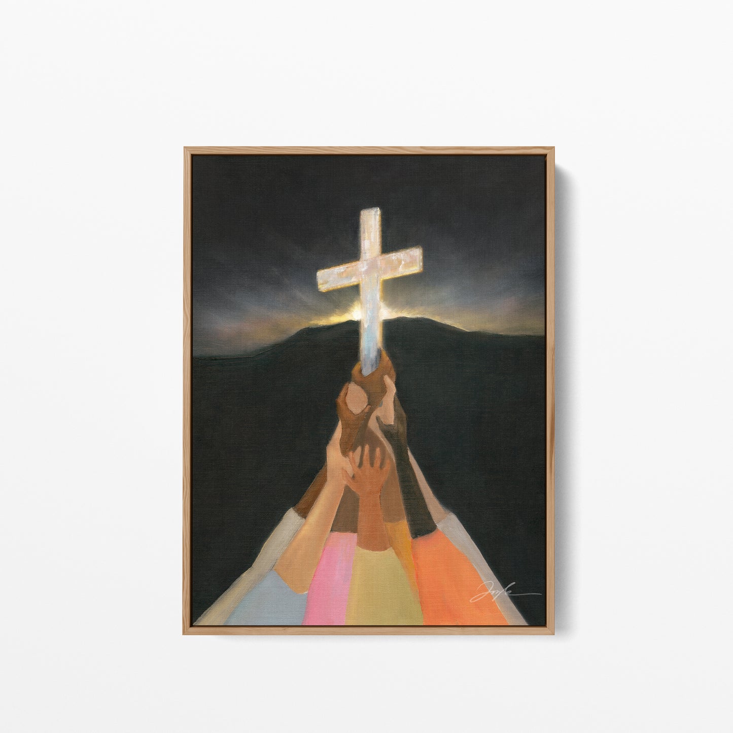 Framed artwork of Christian wall art print of diverse colorful hands lifting up the cross in darkness, with a dark mountain and morning light rising behind it.