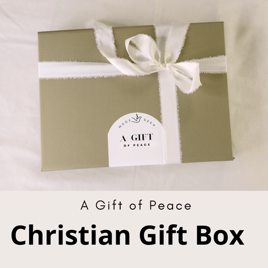 Christian gift box titled “A Gift of Peace” featuring an 8x10 “He restores my soul” art print, Scripture cards, and a gold cross necklace arranged in a premium white box with tissue and ribbon.