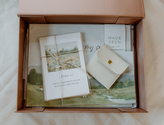 Christian gift box titled “A Gift of Peace” featuring an 8x10 “He restores my soul” art print, Scripture cards, and a gold cross necklace arranged in a premium white box with tissue and ribbon.