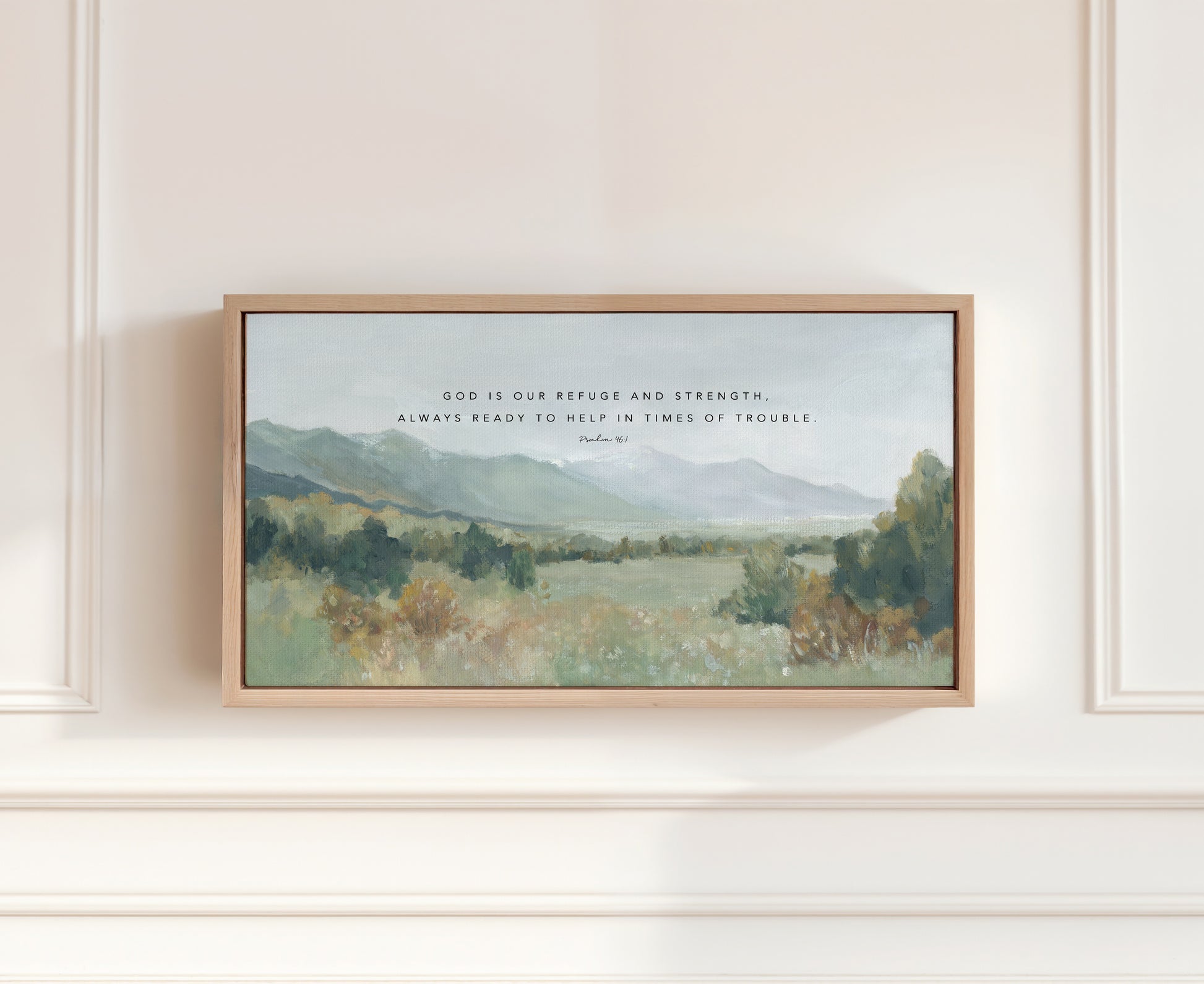 Christian landscape wall art print of valley and mountains Psalm 46:1 framed art on a white wall.