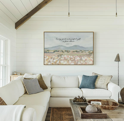 Framed Christian art of Floral field landscape wall art with mountains in the distance featuring James 1:17 Scripture, displayed in living room