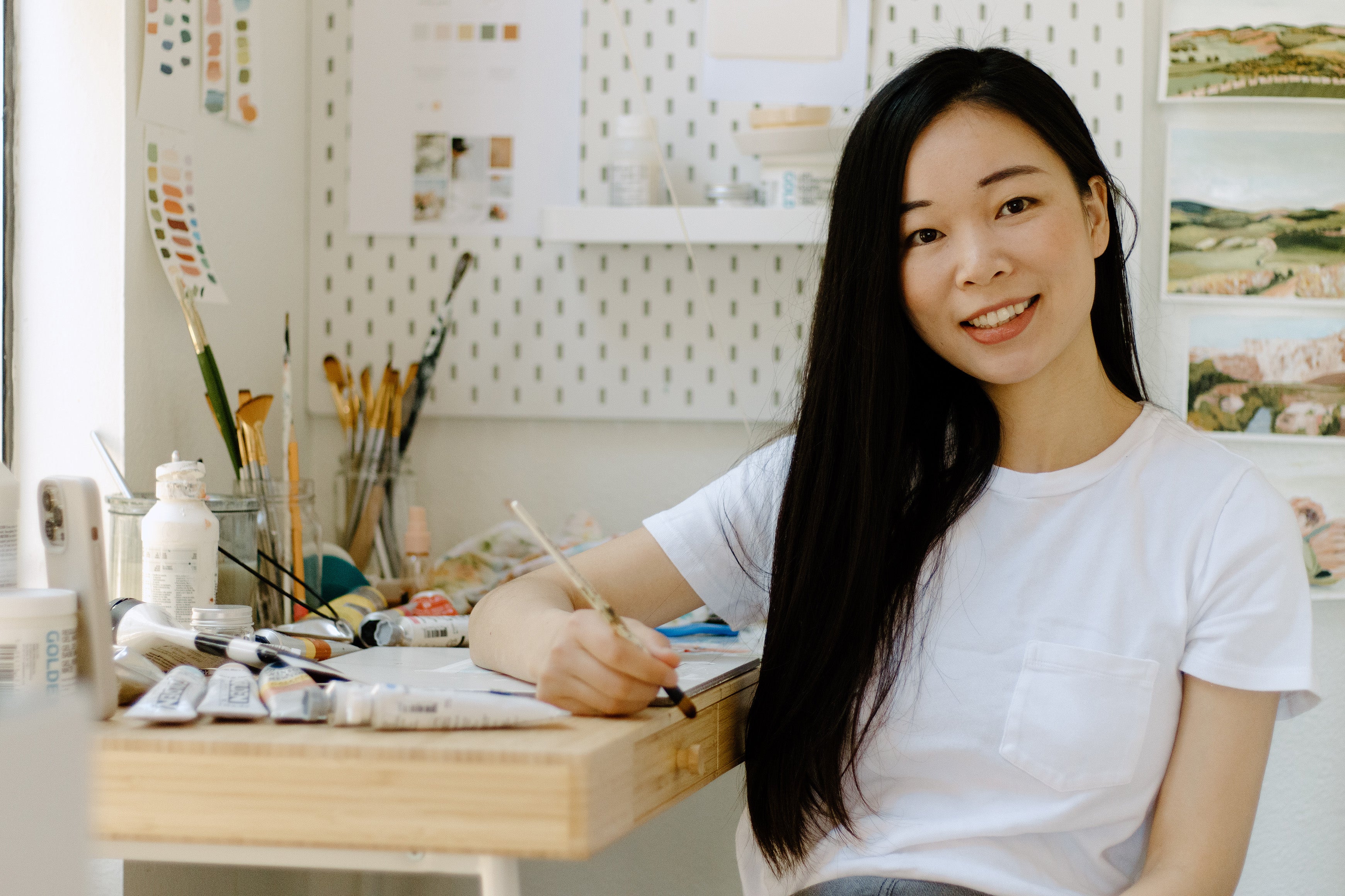 Christian artist Joy Gonzales in her studio  smiling at camera