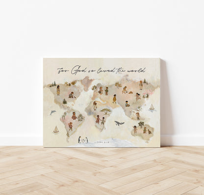 A rectangular world map art print leaning against a white wall on a light wood floor. The print has a soft beige and pink watercolor background with small illustrated figures on each continent and the text 'For God we created the world' at the top.