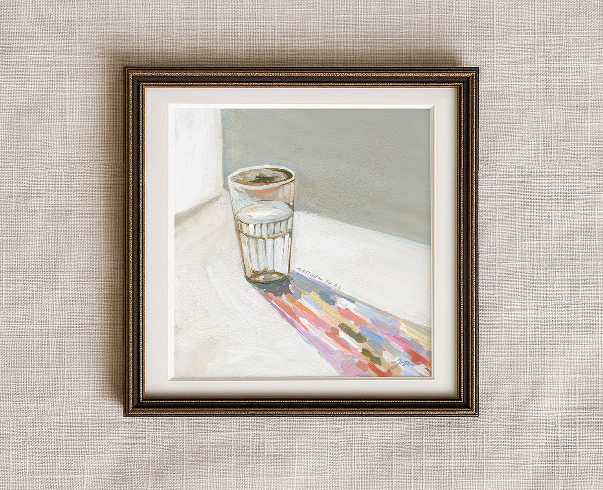 Painting of a glass of water casting a long colorful shadow, with Matthew 10:42 written beside it, framed in a antique bronze frame.